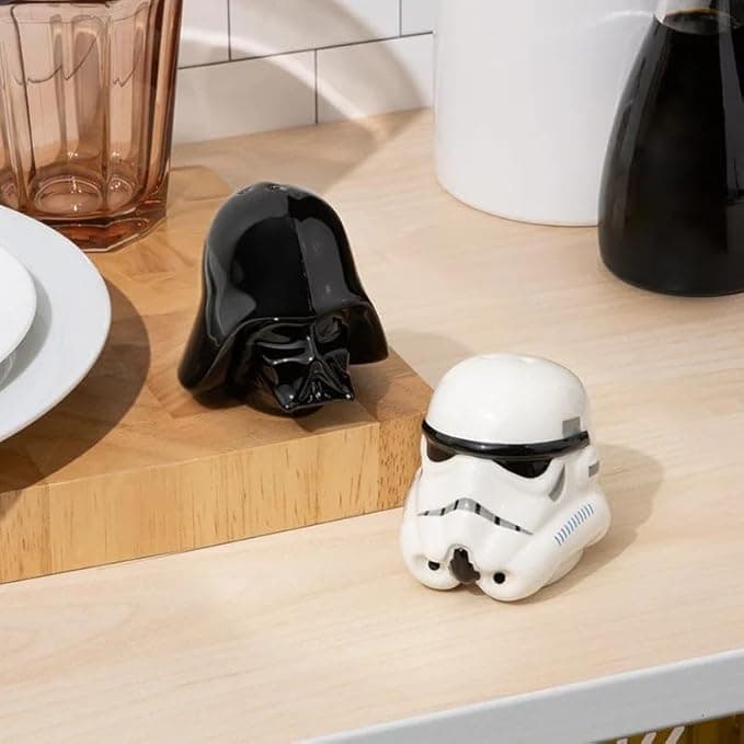 Ceramic salt and pepper shakers shaped like Darth Vader and a Stormtrooper, standing guard on a kitchen table ready to flavor the Force.