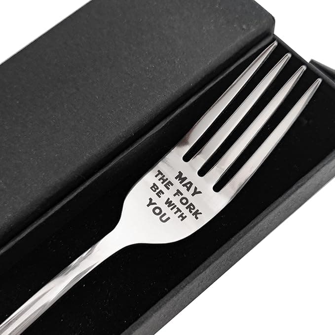 Stainless steel fork engraved with “May The Fork Be With You” resting in a black gift box, ready to serve the galaxy one bite at a time.