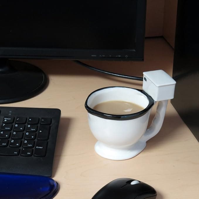 A realistic porcelain toilet-shaped coffee mug designed for gag gifting.
