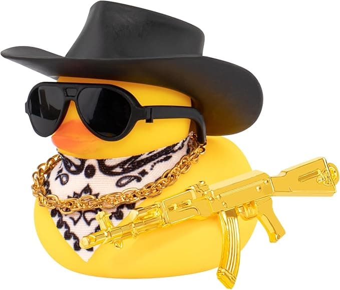 Rubber duck car ornament wearing a black cowboy hat, sunglasses, and necklace on a vehicle dashboard